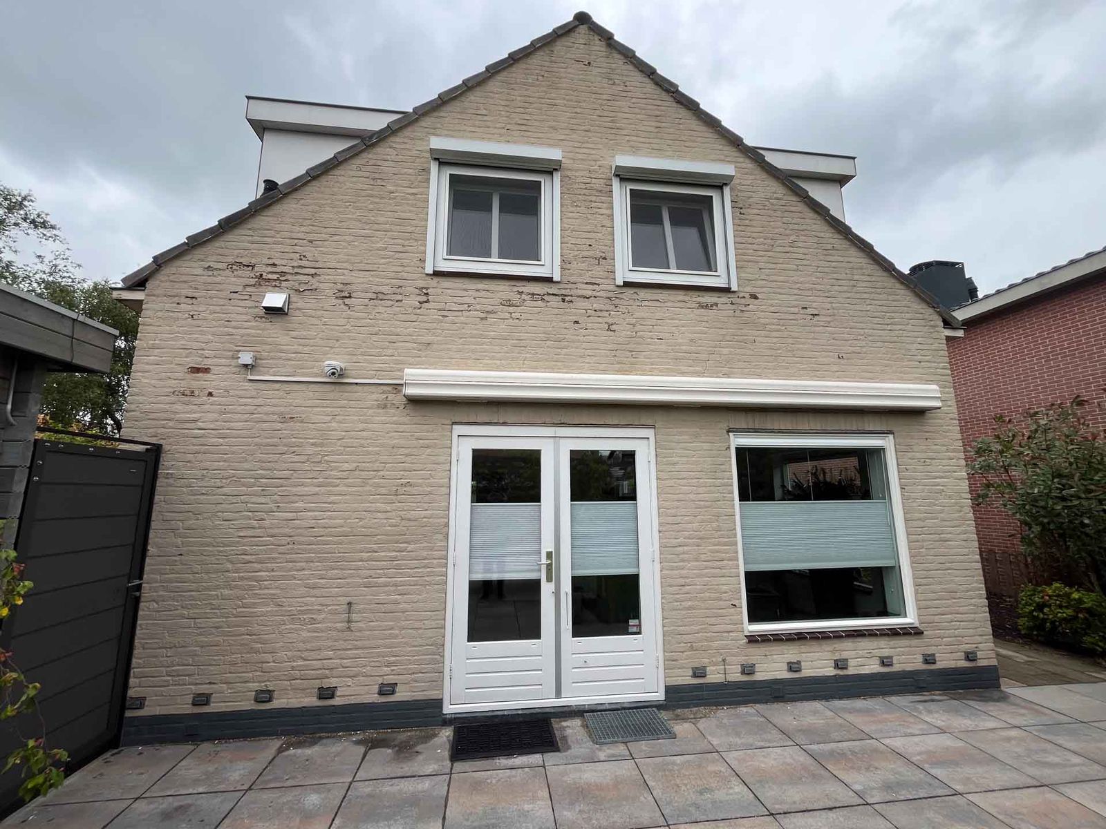 Oude verflaag wordt van een bakstenen gevel verwijderd
