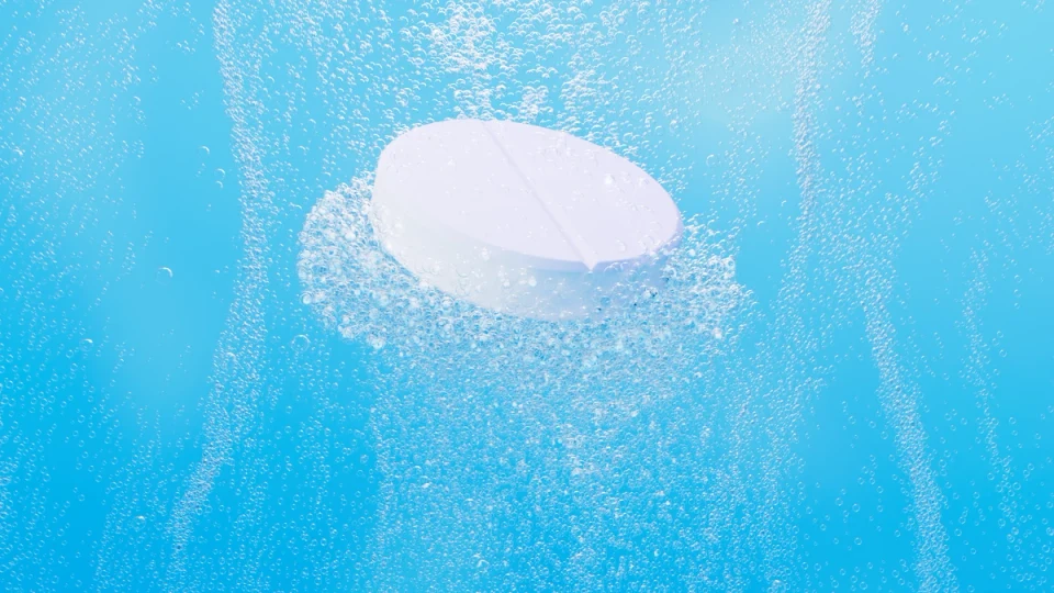Compressa effervescente bianca immersa in bolle su sfondo azzurro