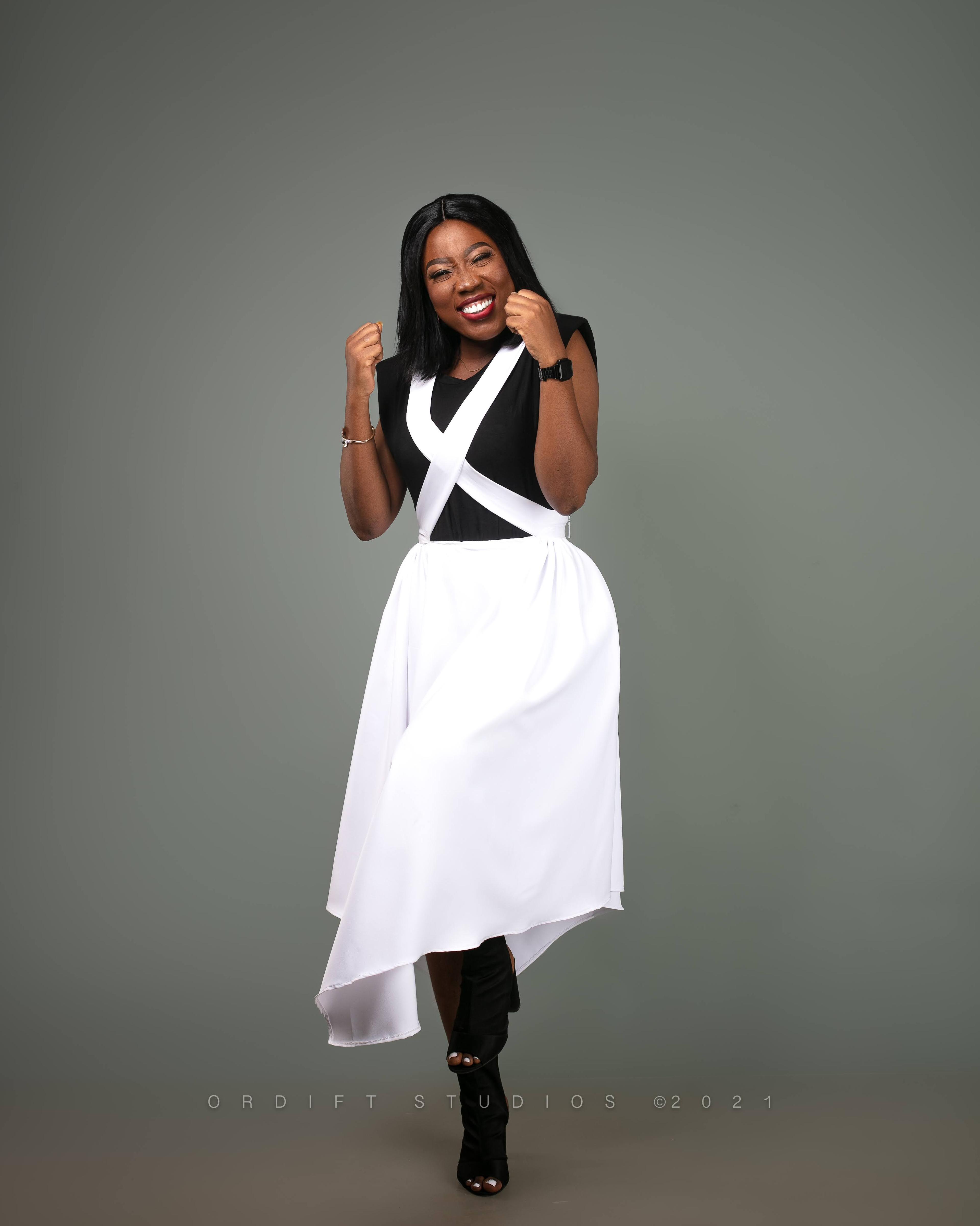 Model posing in a white casual outfit against a muted studio background.