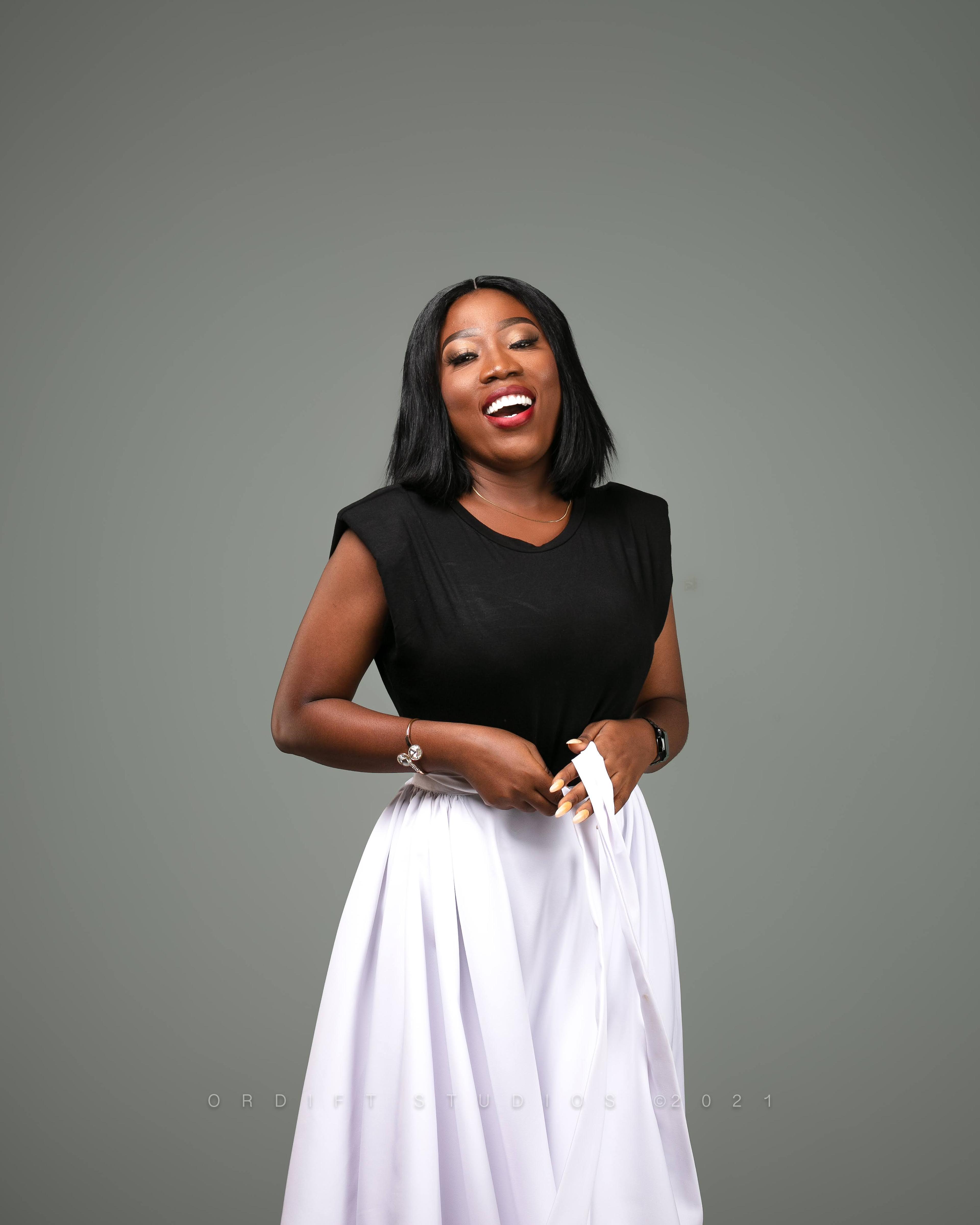 Model wearing a black top and white skirt during a fashion portrait.