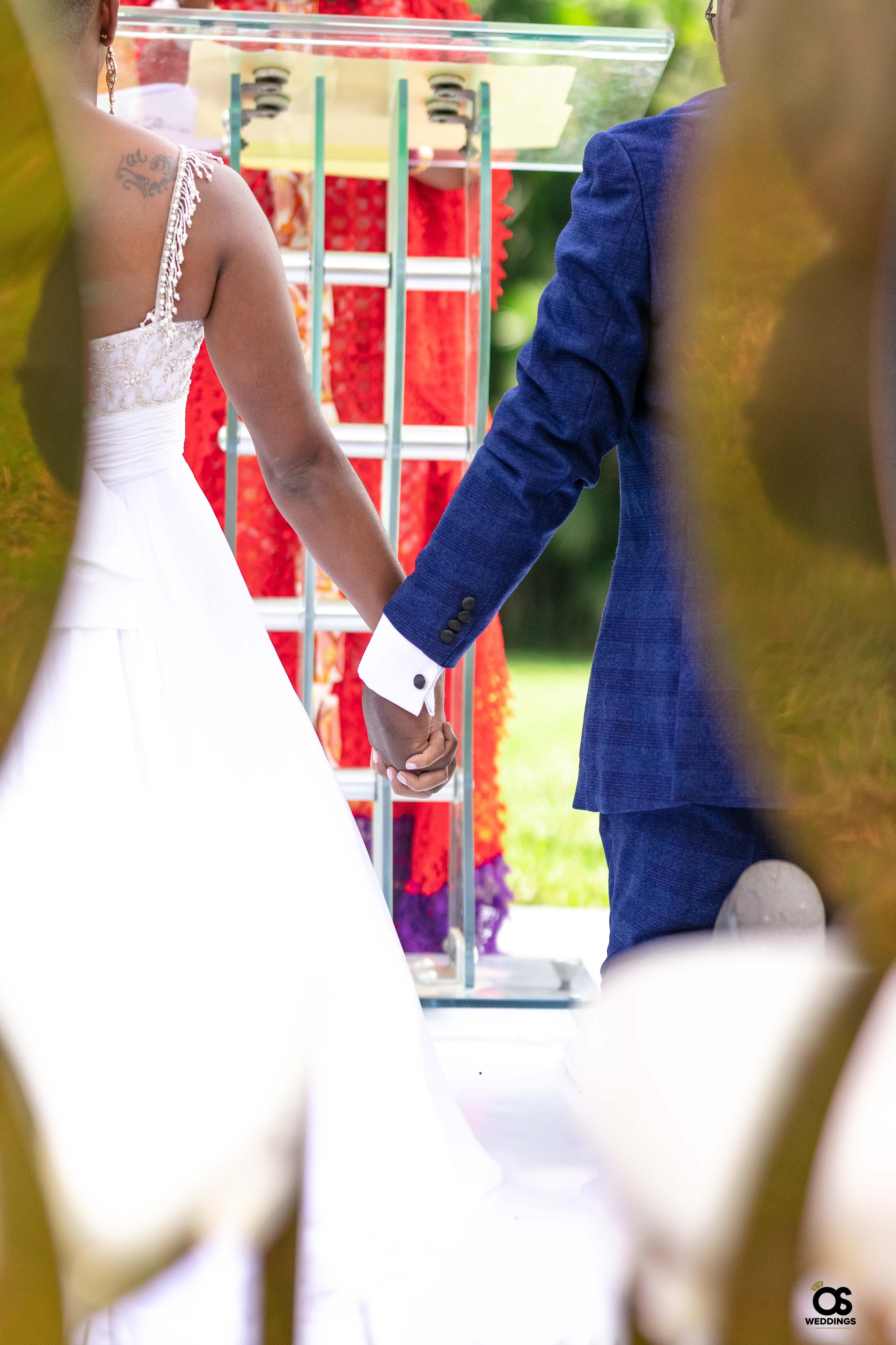 Bride and groom holding hands during the wedding ceremony.