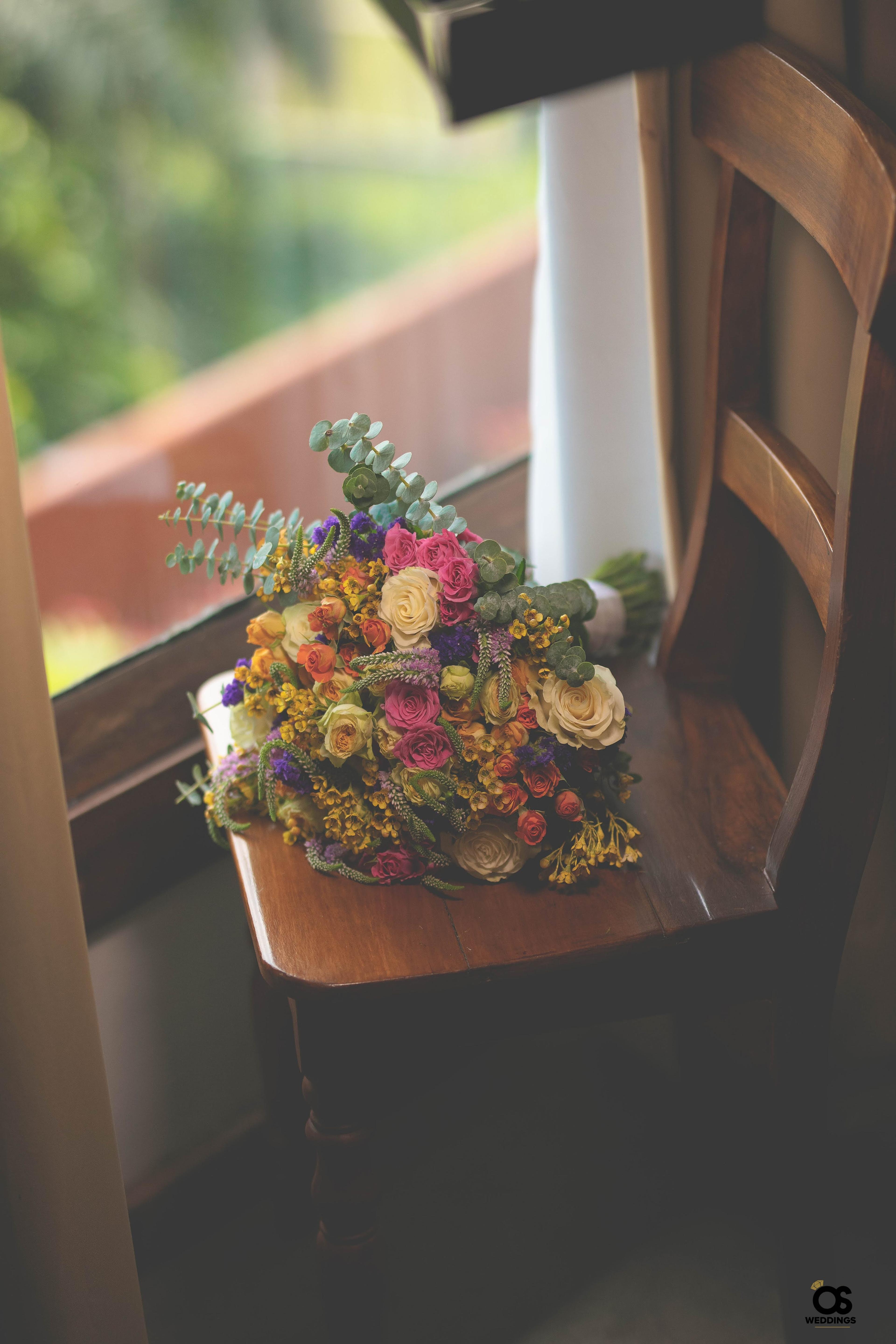 Bridal bouquet resting beside a window during wedding preparations.