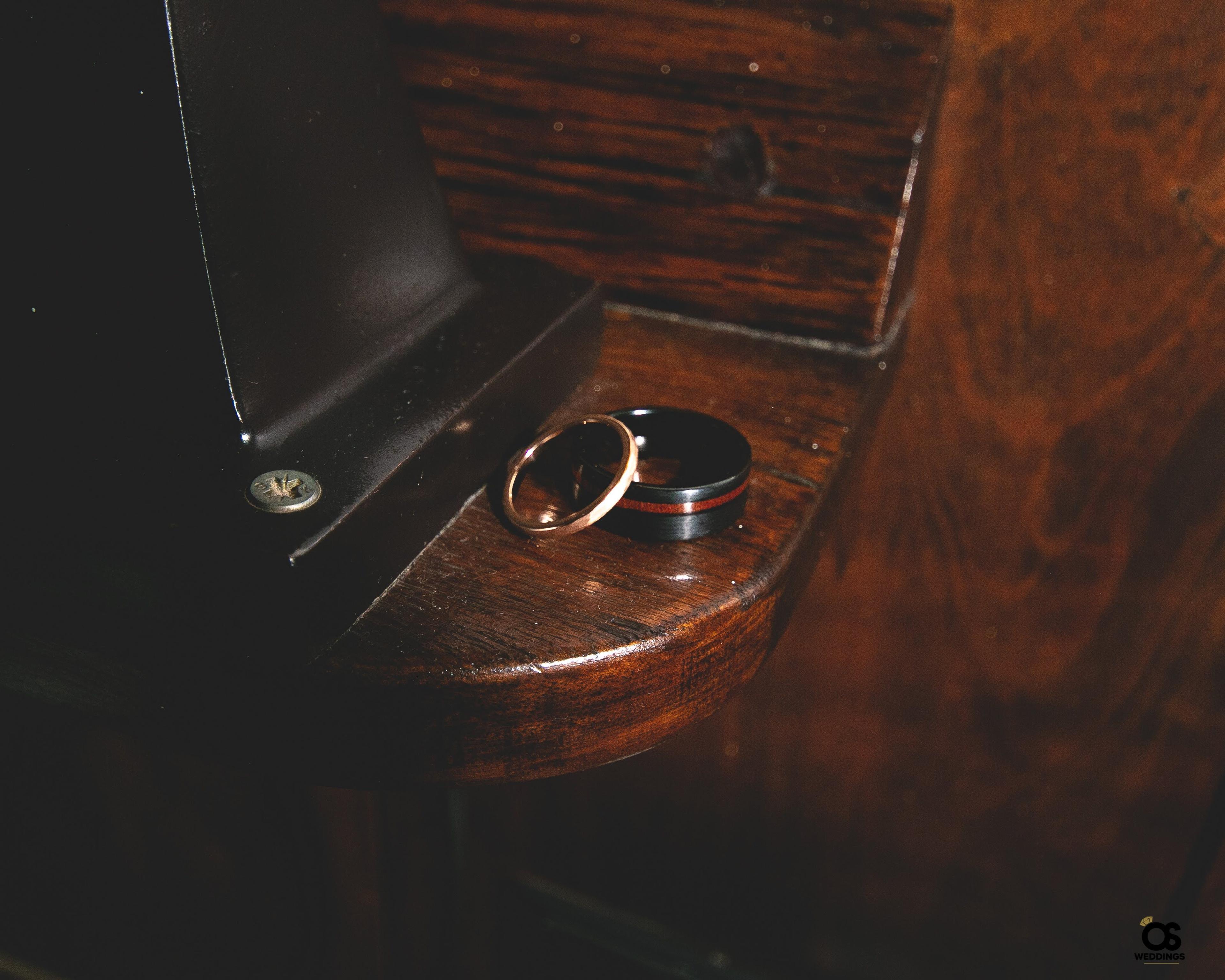 Wedding rings displayed on a wooden surface before the ceremony.
