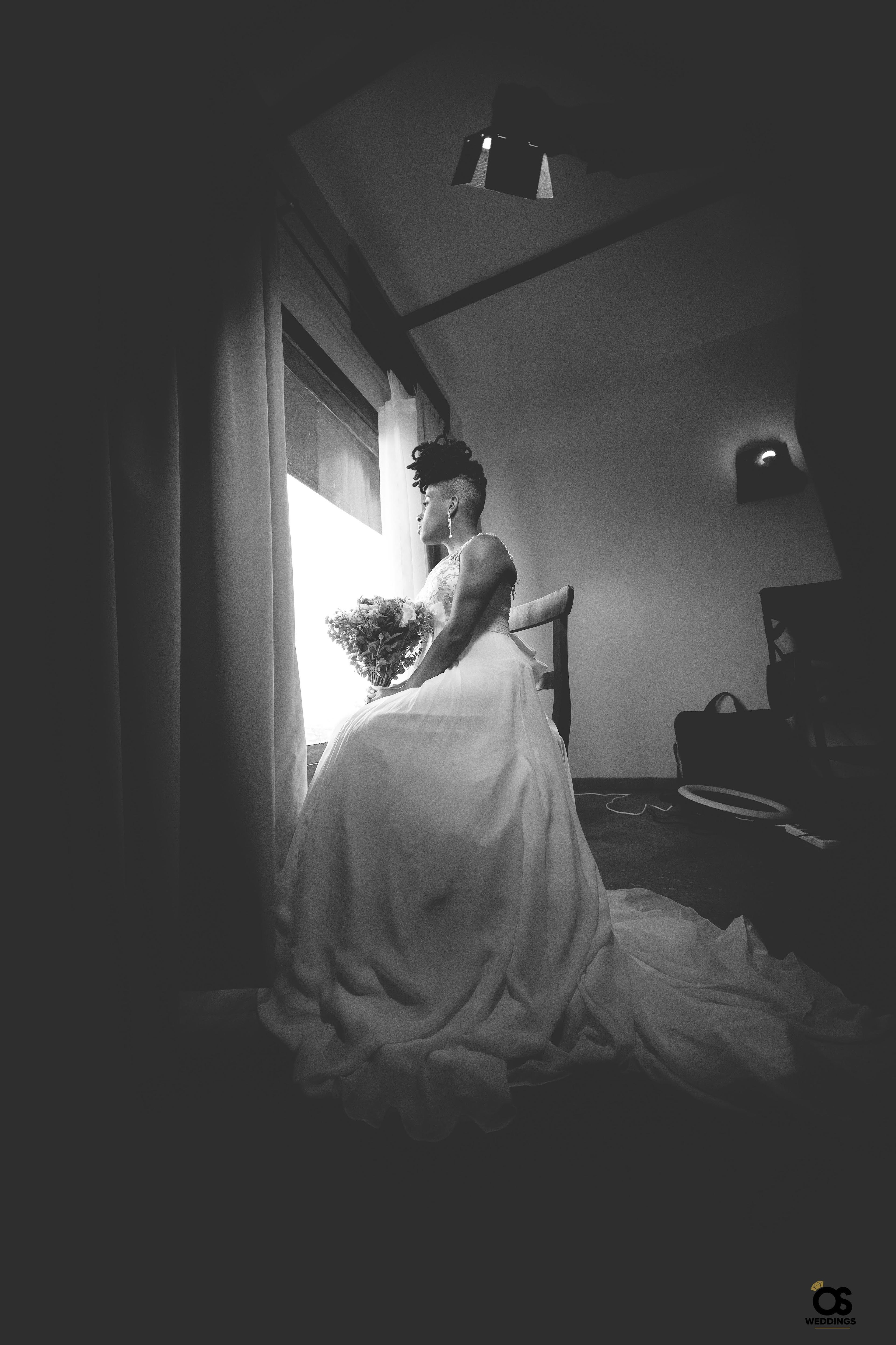 Silhouette portrait of the bride sitting beside a window.