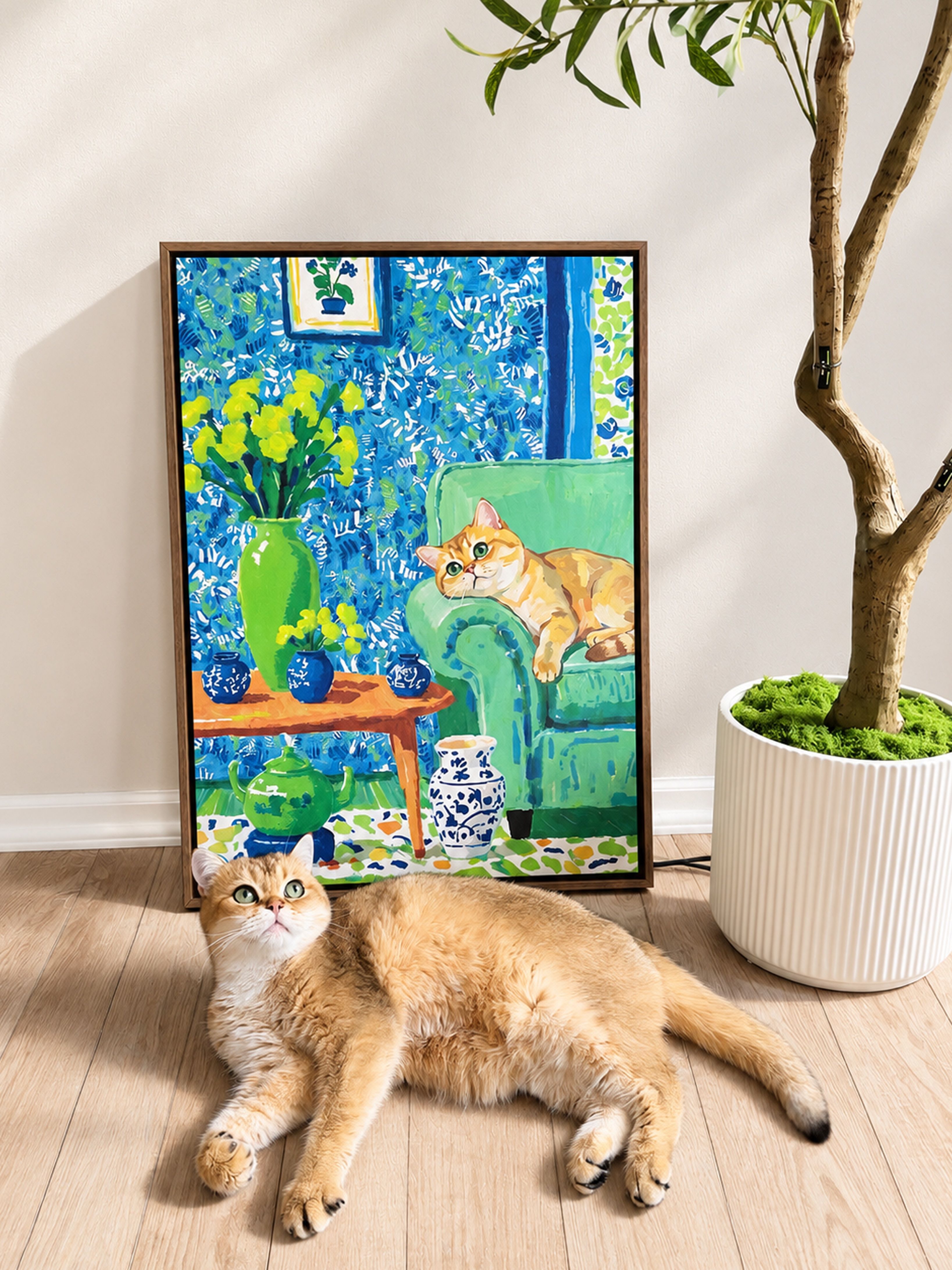 Golden cat relaxing beside a colorful custom pet portrait on framed canvas in a modern home.