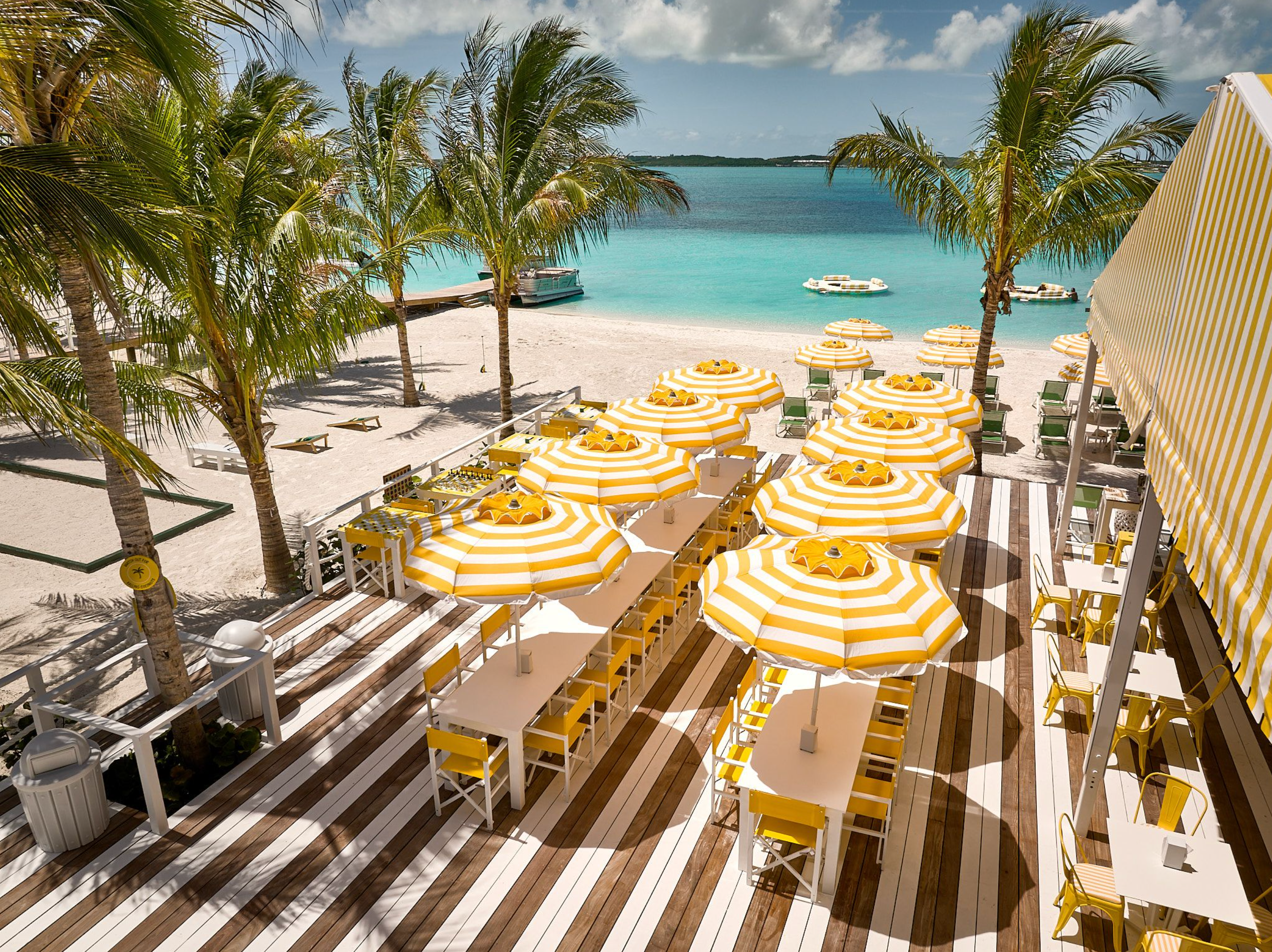 View of a hill, water behind, with a flock of boats in the distance