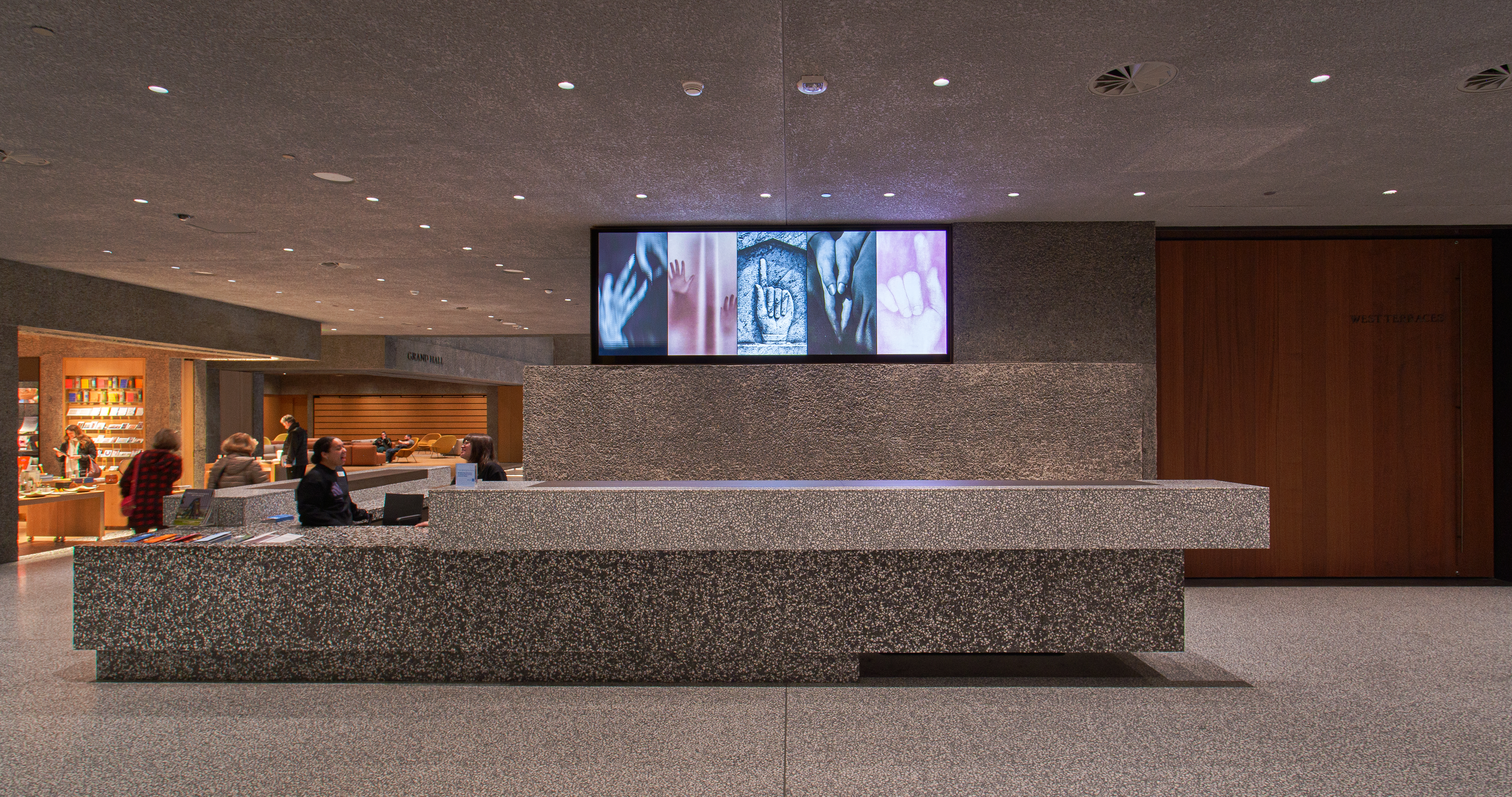A digital screen in the Princeton University Art Museum lobby shows closeups of five artworks of hands