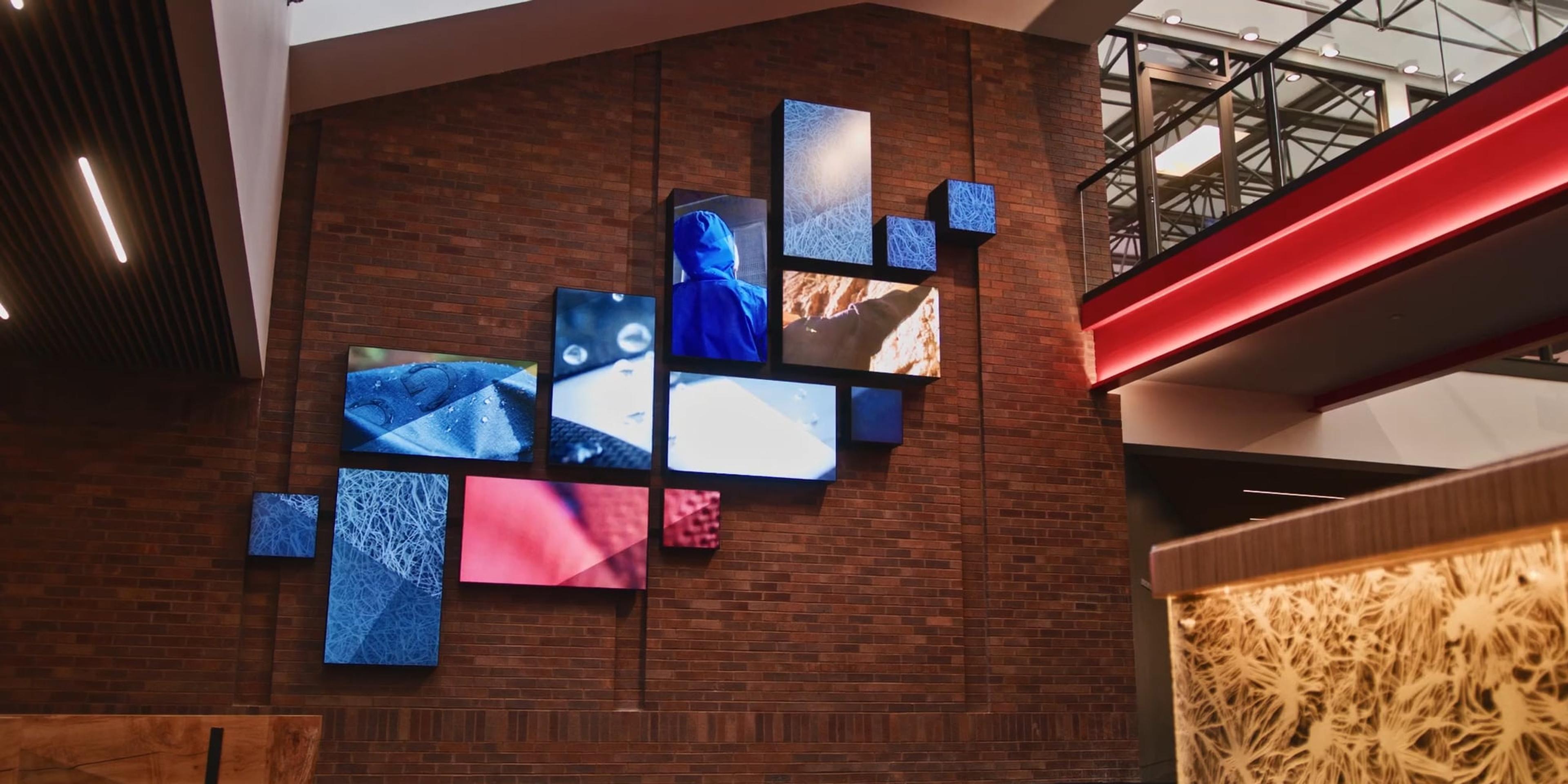 Lobby design featuring custom furnishings, screens inspired by the Eames film “Powers of 10,” ornamental panels, custom seating, and a cafe. Associates, partners, and visitors intermingle, embodying Gore’s promise: Together, improving life.