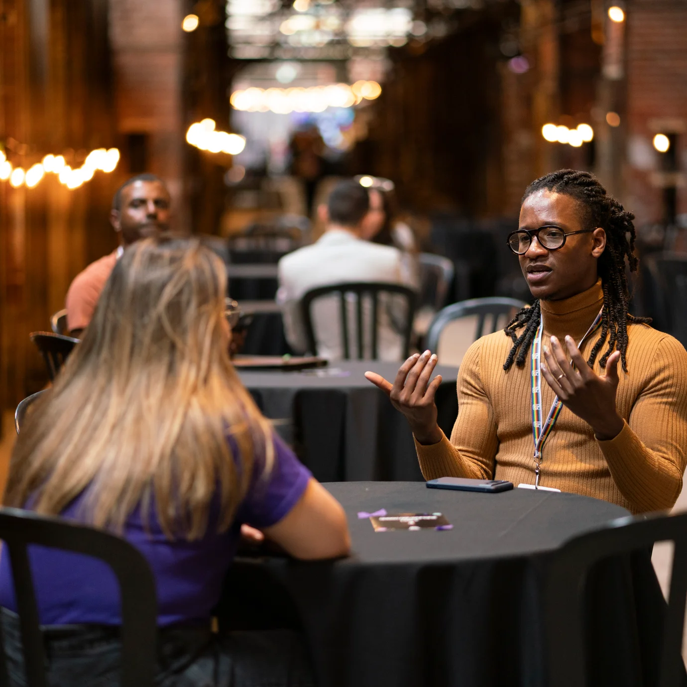 Des participant·e·s réseautent autour d’une table, engagé·e·s dans une conversation lors d’un événement QTQ.