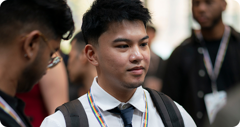 A man in a tie and backpack stands, ready for work or travel.