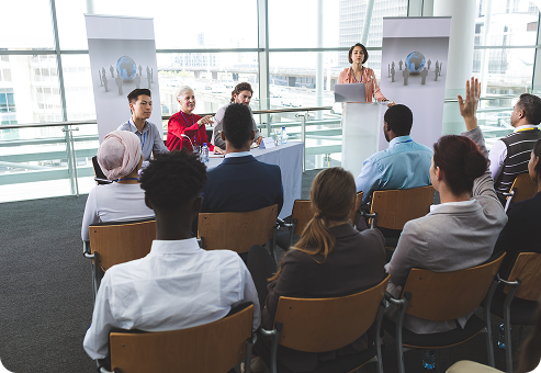 A woman presenting to an audience, engaging them with her speech and visuals.
