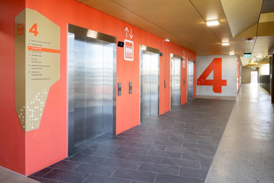 Painted supergraphics on lift core and wayfinding sign