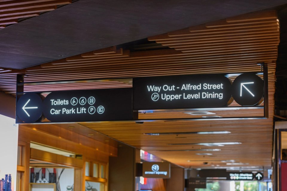 Directional sign suspended from timber batten ceiling