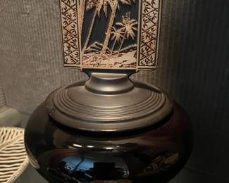 Black urn with decorative etched panel and round base, featured among Asian-style decorative objects in a Beverly Hills estate sale.