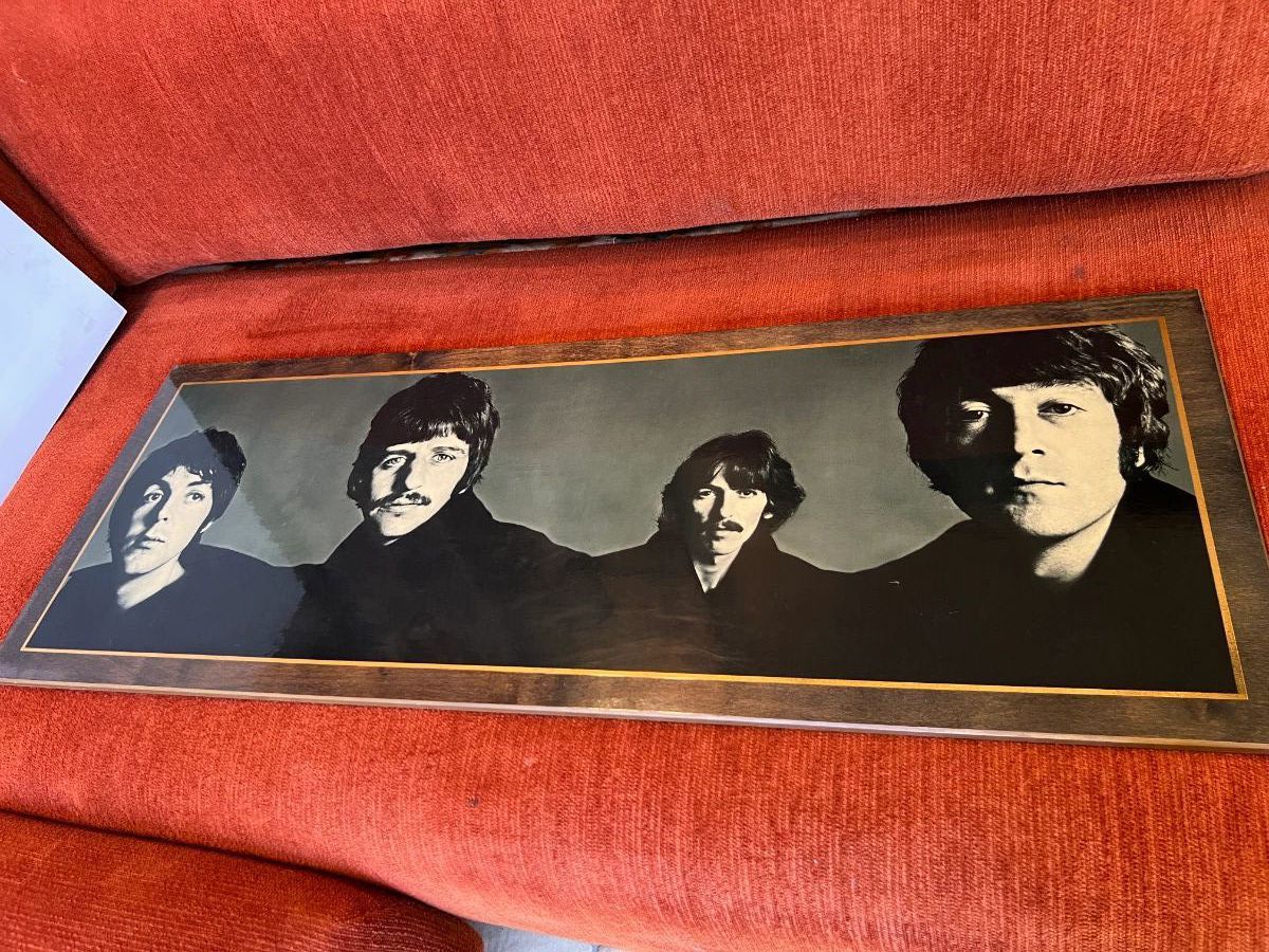 Framed black-and-white Beatles photograph displayed on an orange sofa at a Toluca Lake Hollywood insider estate sale.