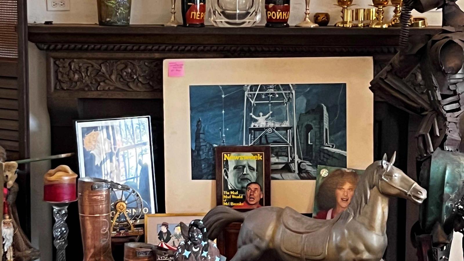 Hancock Park celebrity estate sale display with antiques, Hollywood memorabilia, art, vintage decor, rocking horse, brass pieces, and theatrical collectibles.