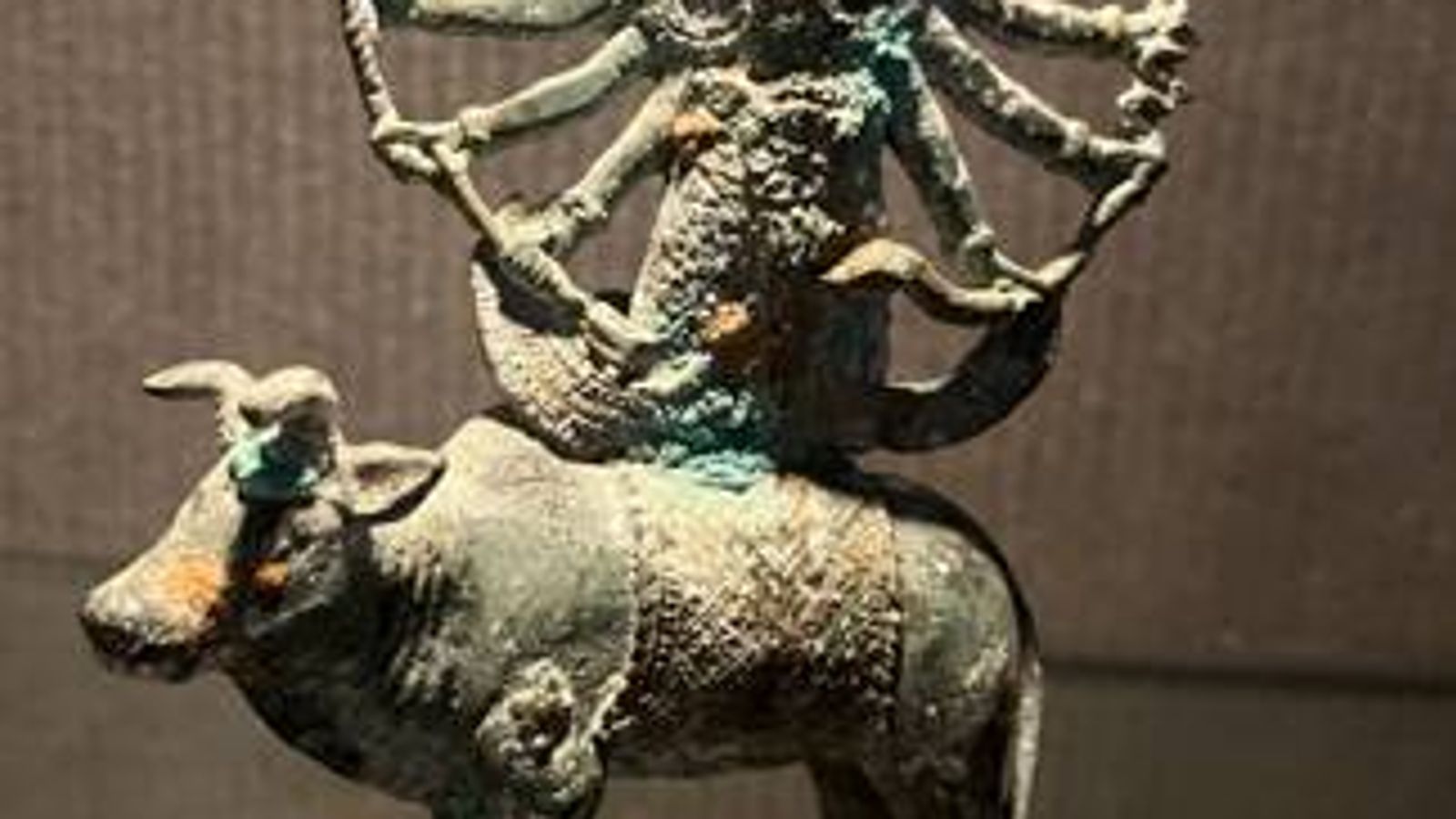 Patinated metal sculpture of a multi-armed deity riding a bull, featured among global art and collectible pieces in a Beverly Hills estate sale.