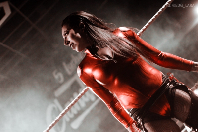 Alexandra posando arriba del ring con el logo de 5 Luchas Clandestino a su espalda