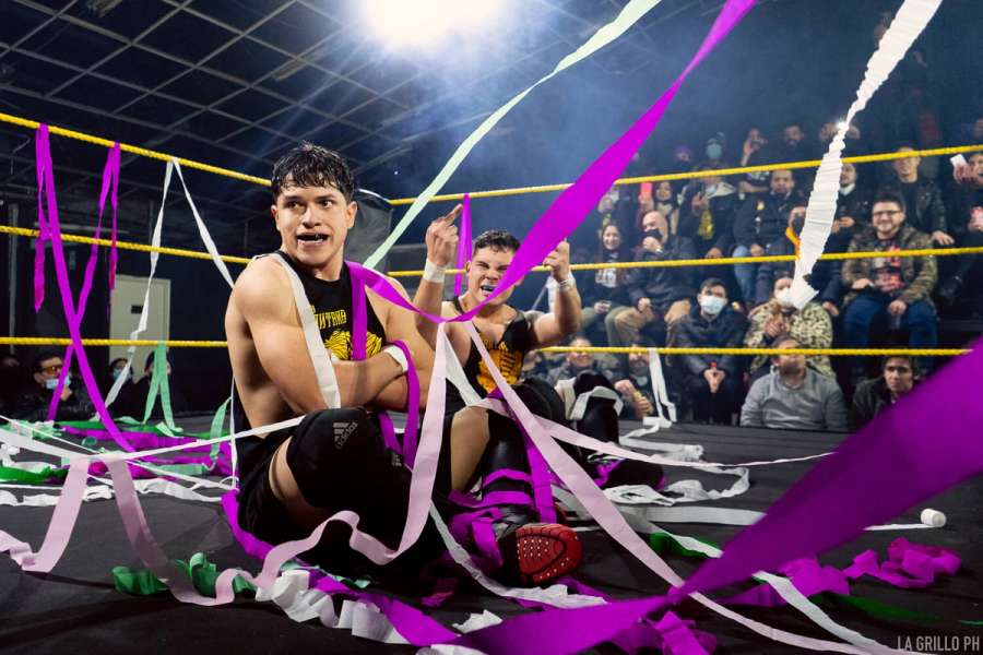 Eric y Cris sentados en el ring cubiertos de serpentinas lanzadas por el público