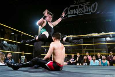 Engranaje Jack golpeando con su rodilla a su rival en el centro del ring