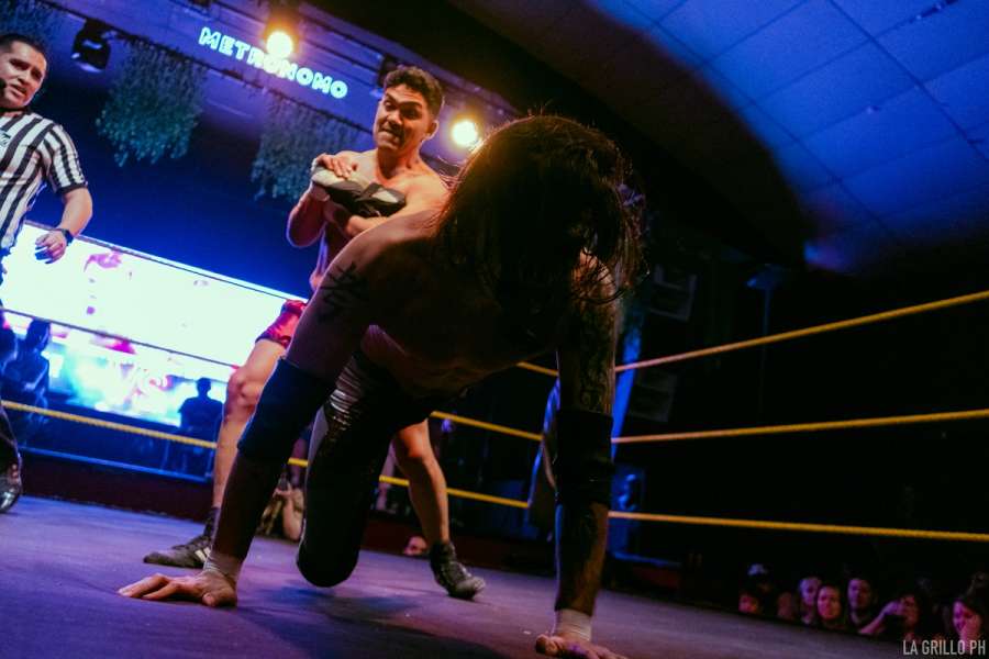 Mauri aplicando candado al tobillo a otro luchador