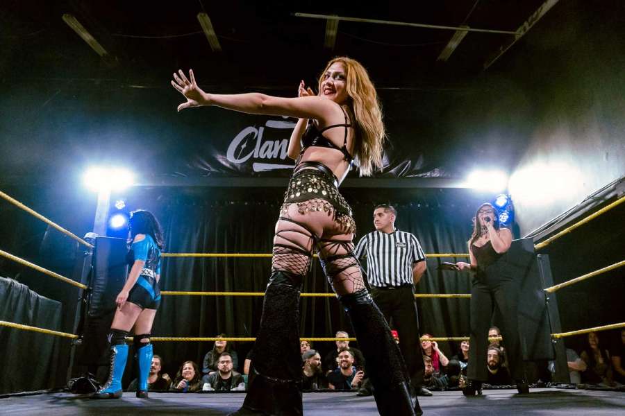 Divinna haciendo una pose en el centro del ring, con Alissa Web, Ivan Navarro y Natalia Stack a su espalda