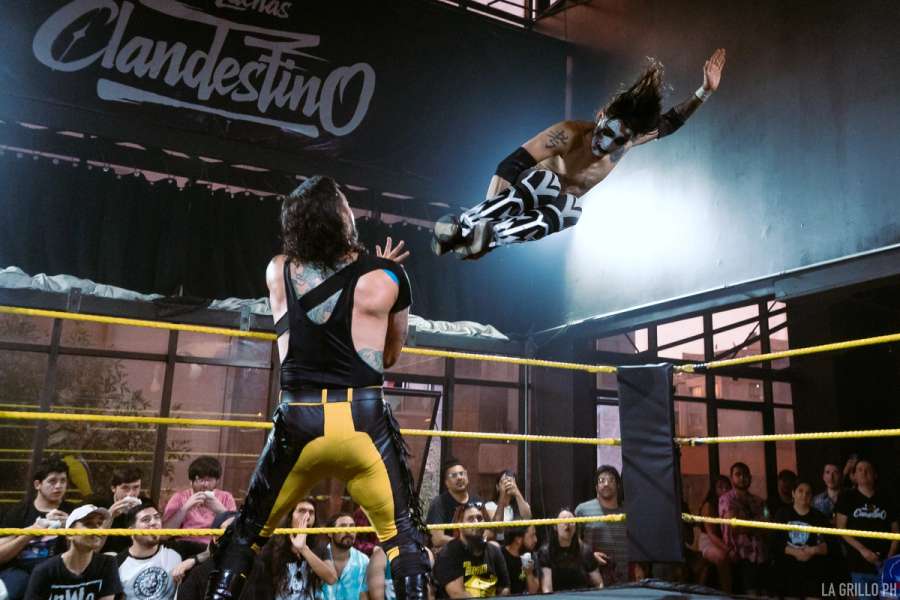Fear volando en dirección al pecho de Axel para darle una Drop Kick