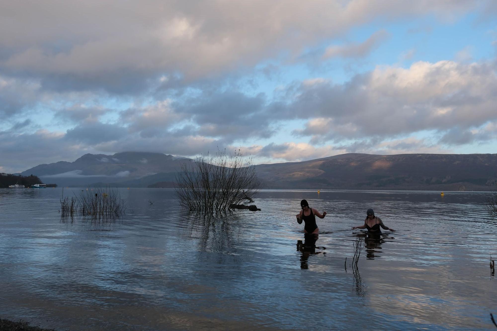 A swimmer walking into the loch for a cold dip