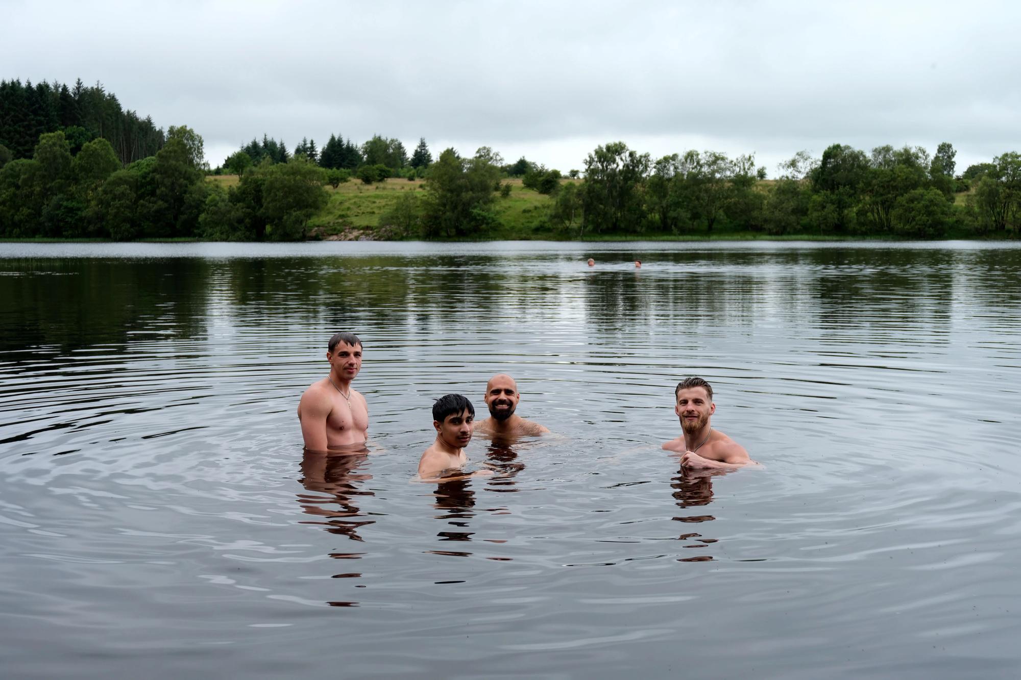 A group of friends in the loch, smiling for the camera.
