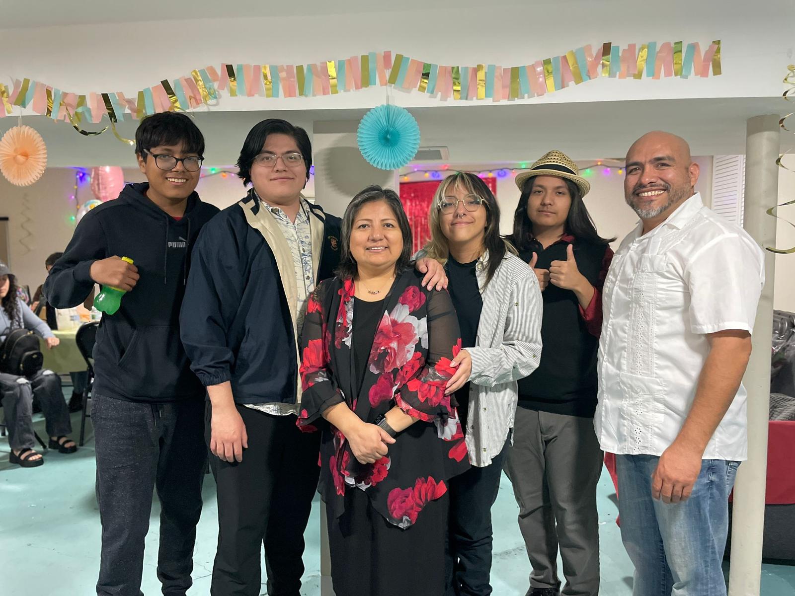 6 people stand together smiling.