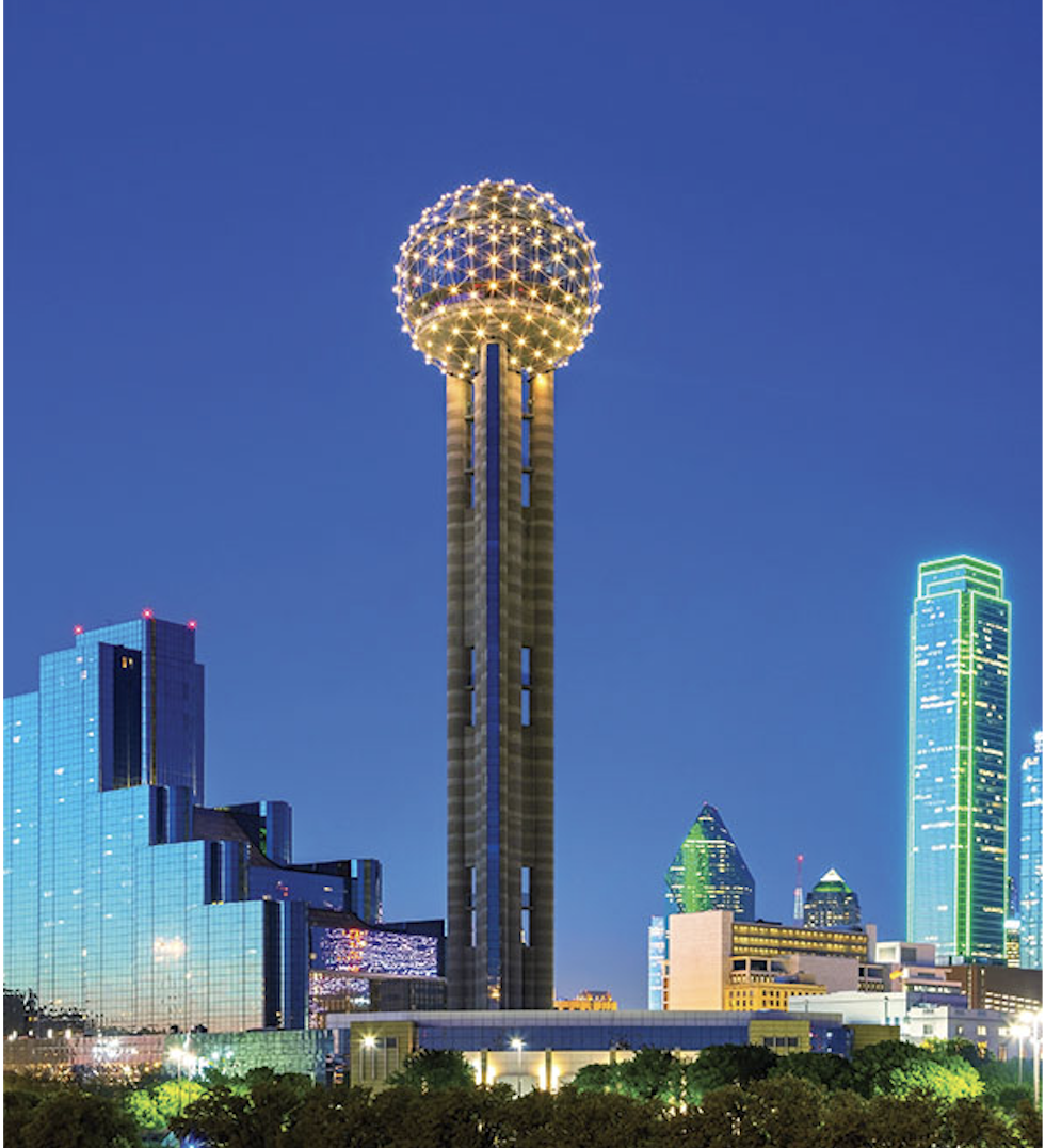 Reunion Tower lit at dusk above the Dallas skyline