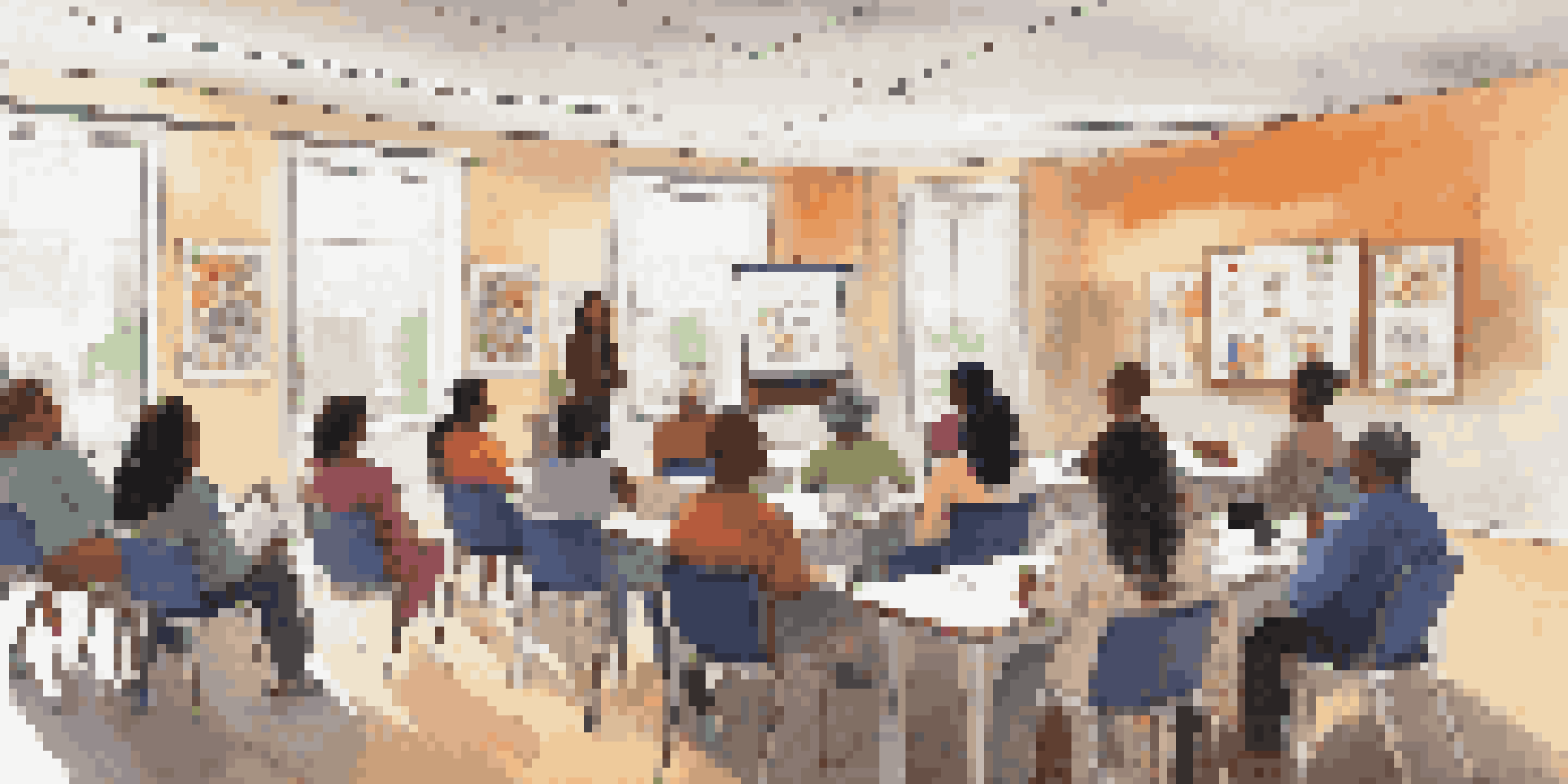 A diverse group of people attending a community health workshop, with an instructor presenting information in a bright room filled with health posters.