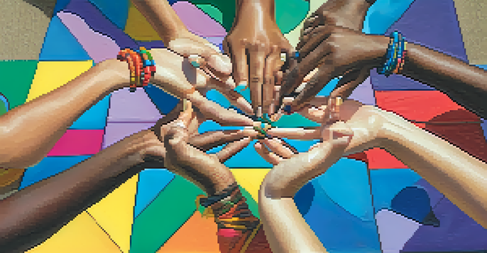 A close-up of hands forming a heart shape surrounded by yoga mats and joyful faces, symbolizing community in laughter yoga.