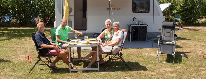 Familie aan tafel voor caravan