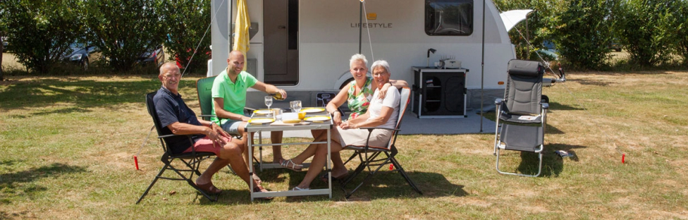 Familie aan tafel voor caravan