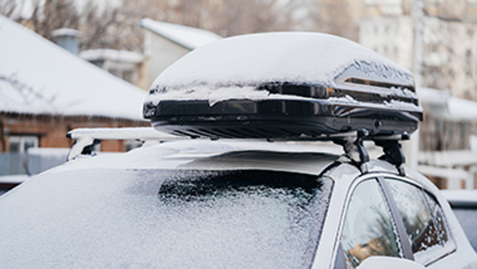 Besneeuwde auto met dakkoffer