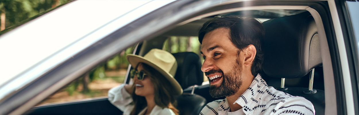 Man en vrouw vrolijk in de auto 