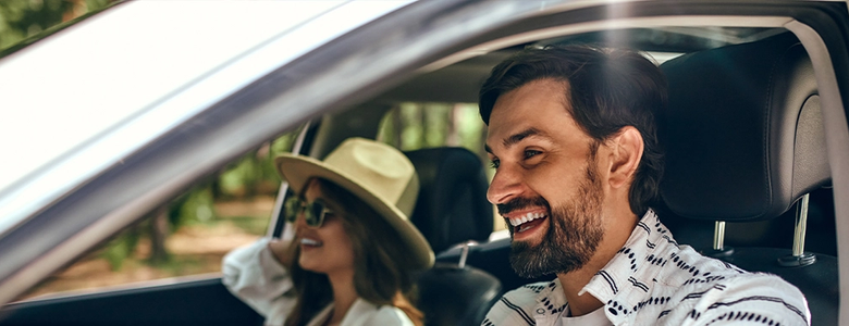 Man en vrouw vrolijk in de auto 