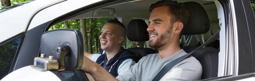 rijinstructeur met leerling in lesauto