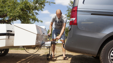 Man die vouwwagen koppelt aan auto