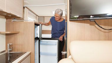 Vrouw bij koelkast in camper