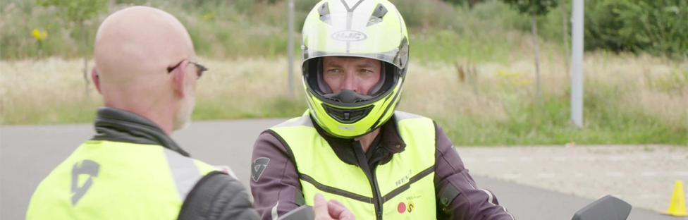 Man op lesmotor met instructeur