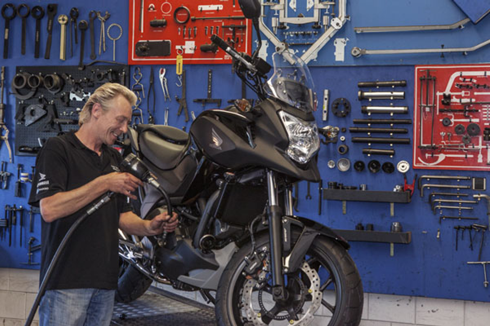 Man in werkplaats met motor