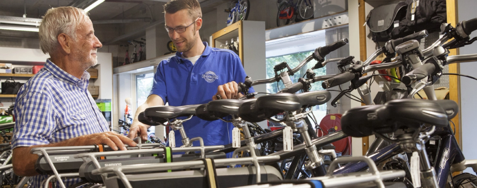 Man met verkoper in fietsenwinkel met e-bike