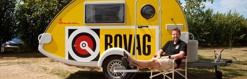 Man op stoel voor BOVAG caravan