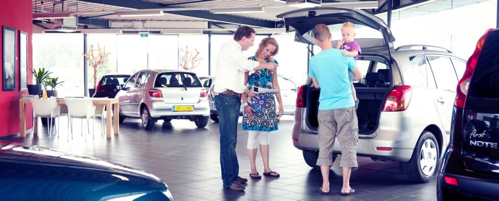 Familie voor auto in dealership