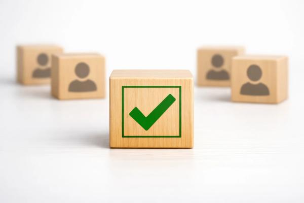 Houten blokjes met poppetjes en groen vinkje