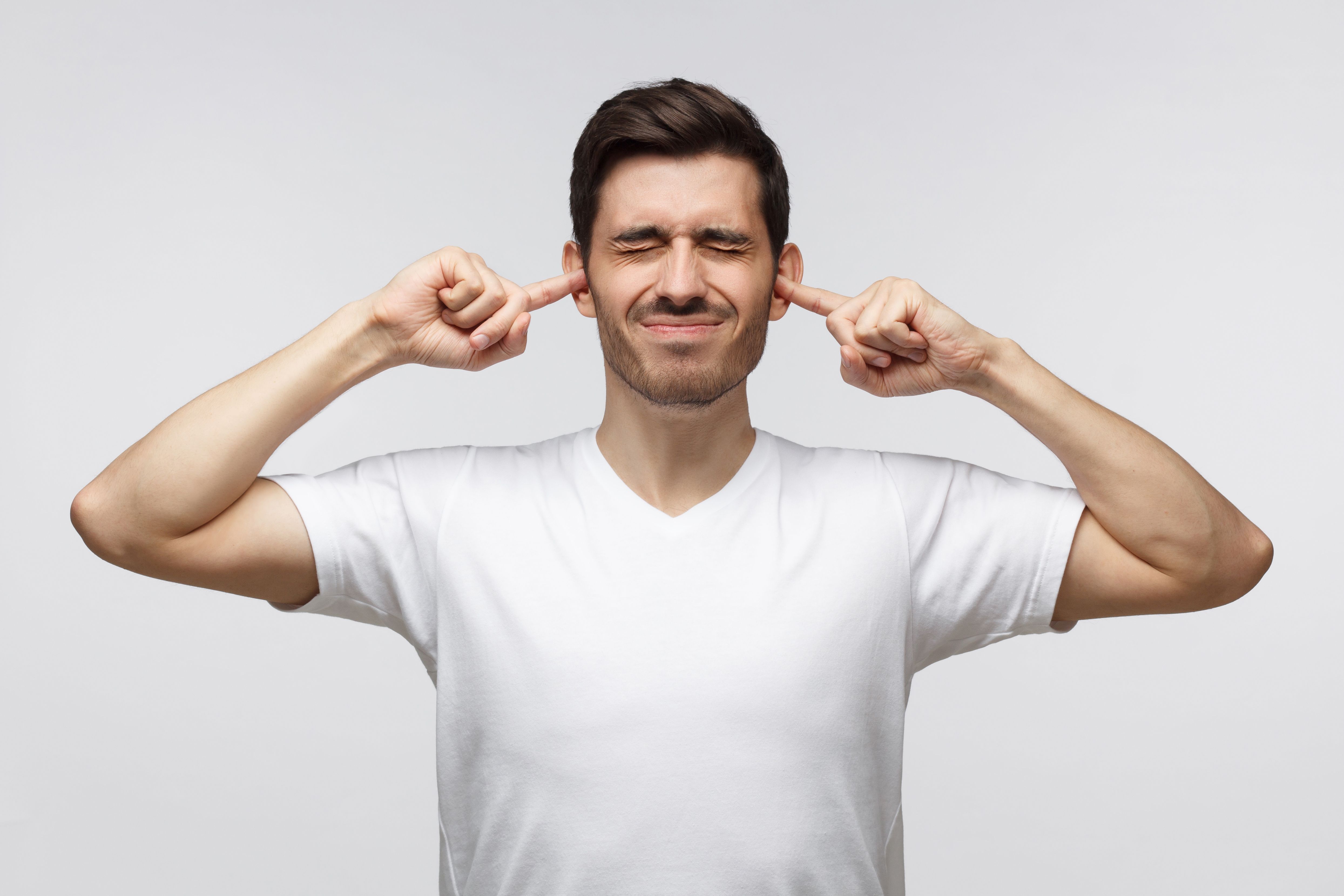 Man met vingers in zijn oren