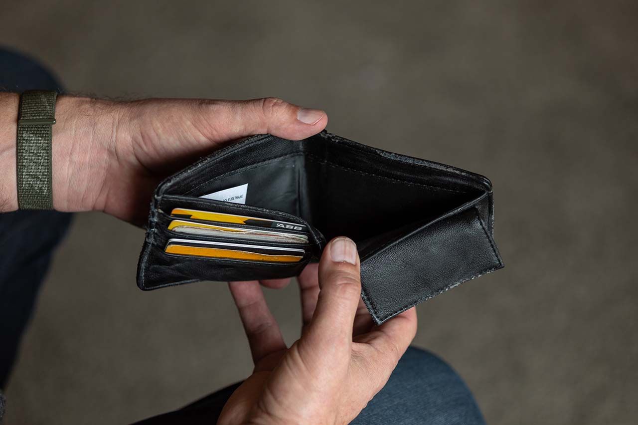 Man's hands opening an empty black wallet