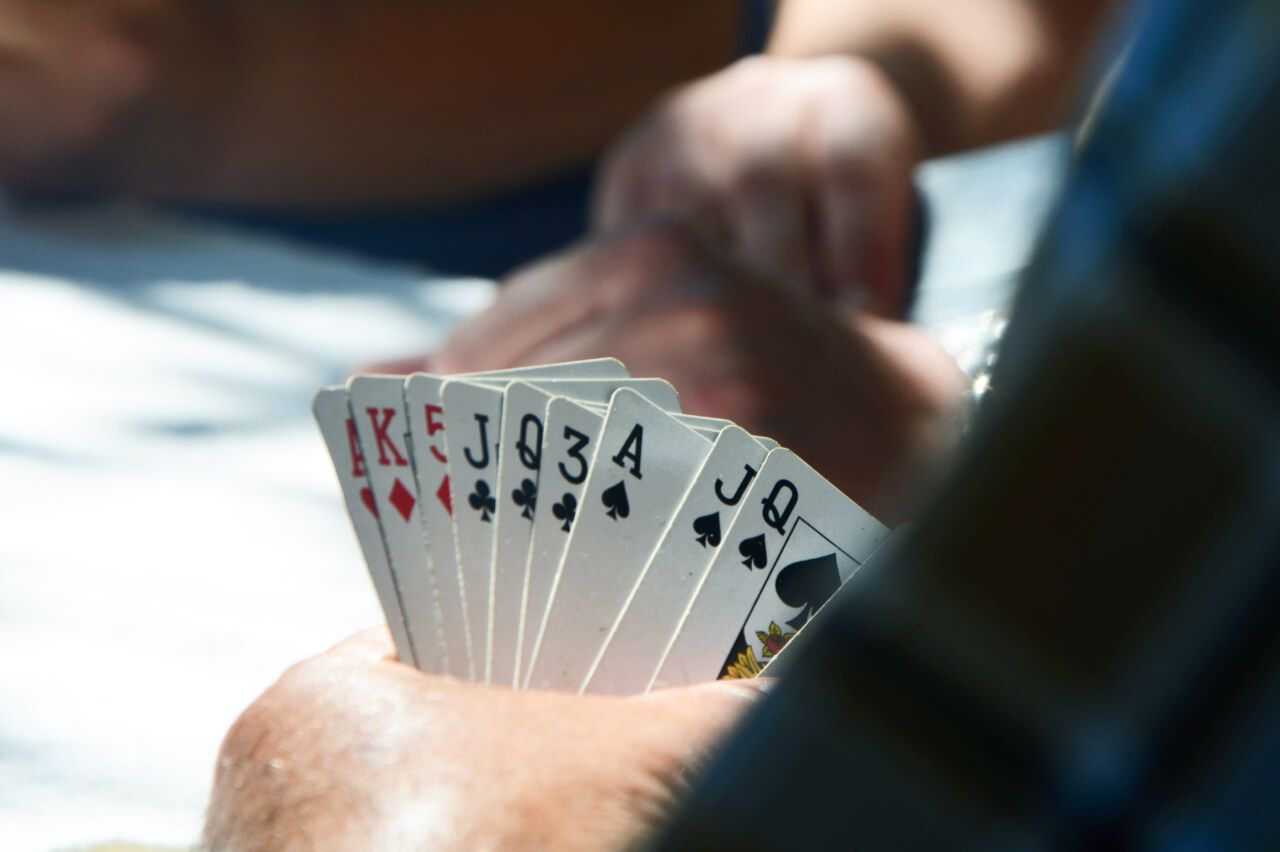 Close up of a person gambling holding a set of cards  